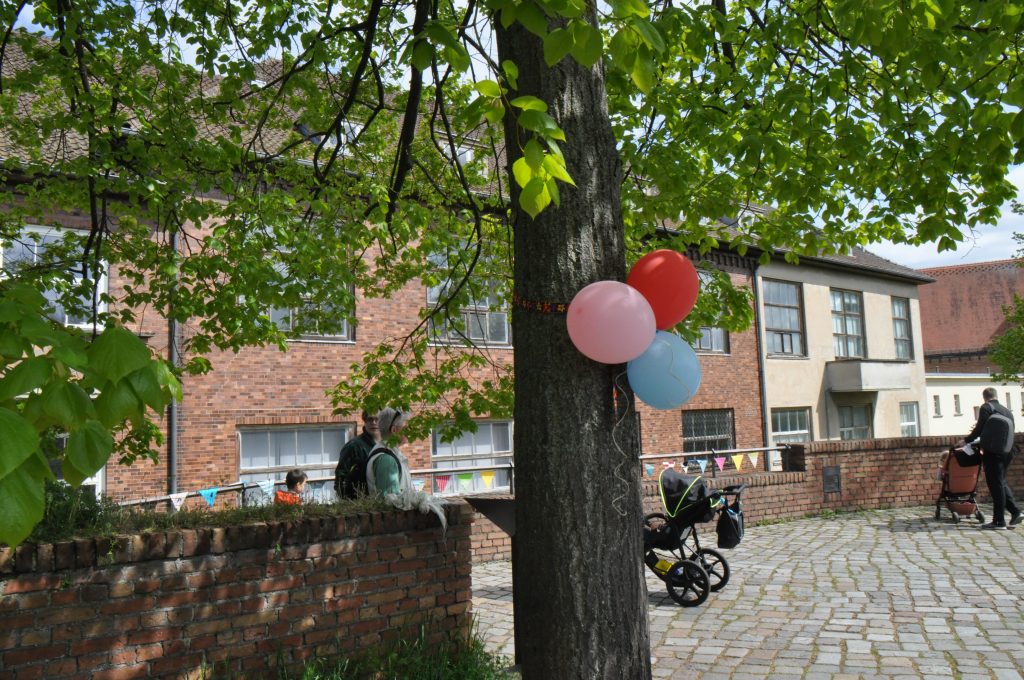 Drei farbige Luftballons an einem Baumstamm gebunden