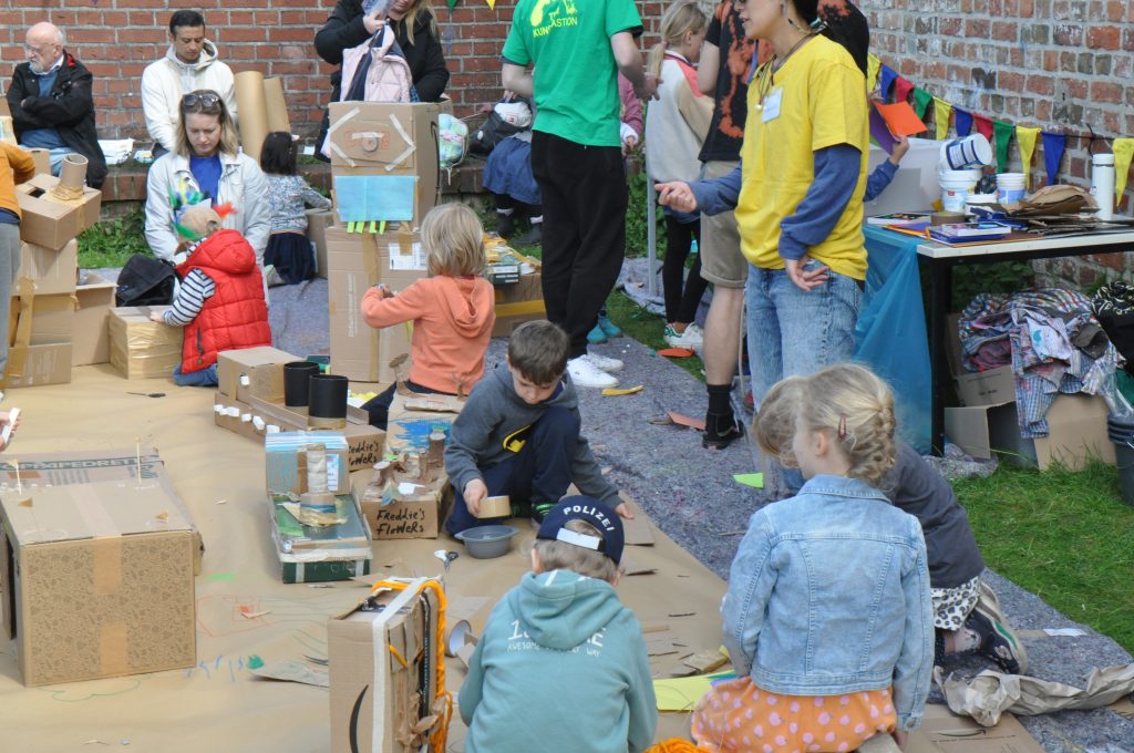 Kinder bauen und spielen mit Kartons aus Pappe