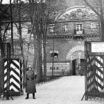 Ein Wehrmachtssoldat steht an einem Wachhaus vor dem Torhaus der Zitadelle