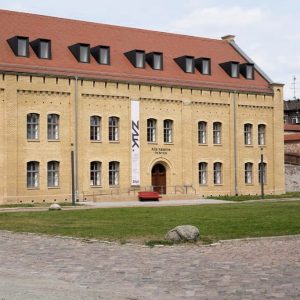 Frontansicht auf das Zentrum für aktuelle Kunst. Am Gebäude hängt ein langes Banner mit dem Kürzel ZAK.