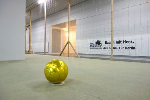 Ein goldener Ball liegt in der Kunstinstallation des Künstlers Pfelder