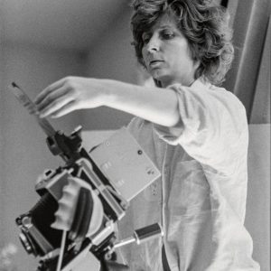 Portrait von Vera Mercer, die eine Fotokamera benutzt.