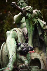 Eine Statue mit einem Erwachsenen und einem kleinen Engel, der Engel trägt Kopfhörer.