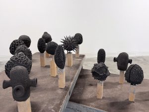 Schwarze abstrakte Kunstwerke von Reiner Maria Matysik, die auf dem Boden stehen.